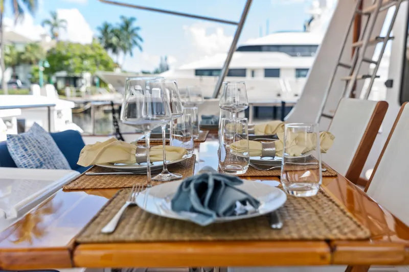 Slide: The Image of Elegant dining setup on 2005 Grand Banks 72 Aleutian RP yacht, featuring glassware and napkins. - 55