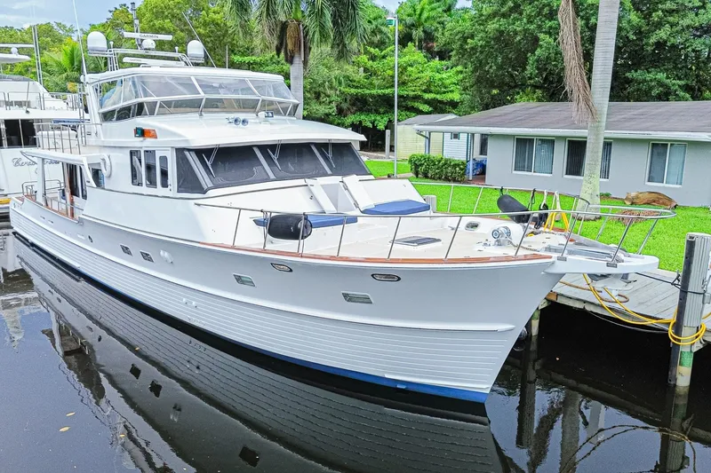 Slide: The Image of 2005 Grand Banks 72 Aleutian RP yacht docked by a lush, tropical setting. - 3
