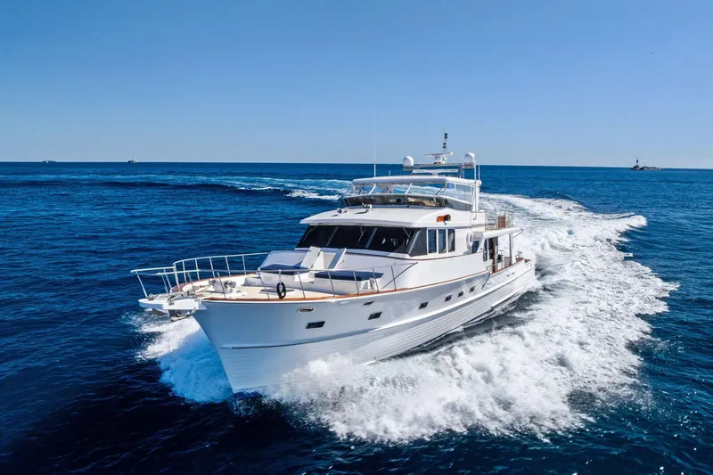 Slide: The Image of 2005 Grand Banks 72 Aleutian RP yacht cruising on open sea under clear blue sky. - 185