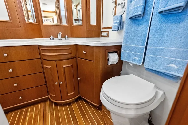 Slide: The Image of Luxurious bathroom in 2005 Grand Banks 72 Aleutian RP yacht with wood cabinetry and blue towels. - 105