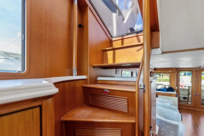 Slide: The Image of Interior view of 2005 Grand Banks 72 Aleutian RP yacht with wooden stairs and seating area. - 90