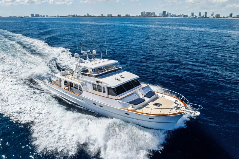 Slide: The Image of 2005 Grand Banks 72 Aleutian RP yacht cruising on open sea with city skyline. - 32