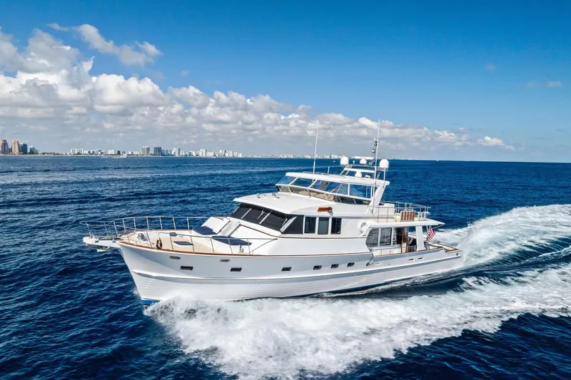 Slide: The Image of 2005 Grand Banks 72 Aleutian RP yacht cruising on open ocean under clear blue sky. - 180