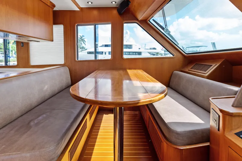Slide: The Image of Luxurious interior of 2005 Grand Banks 72 Aleutian RP yacht with wooden table and seating. - 89