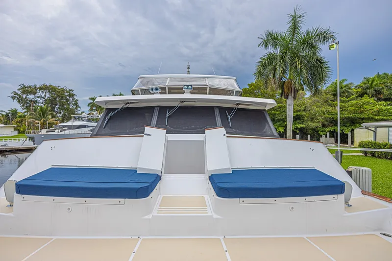 Slide: The Image of 2005 Grand Banks 72 Aleutian RP yacht with blue seating, docked near palm trees. - 18