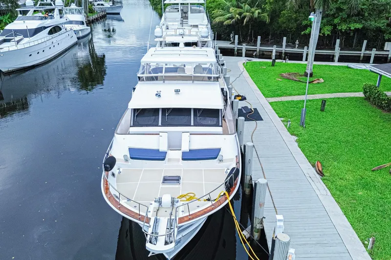 Slide: The Image of Grand Banks 72 Aleutian RP 2005 yacht docked by a lush green waterfront. - 4