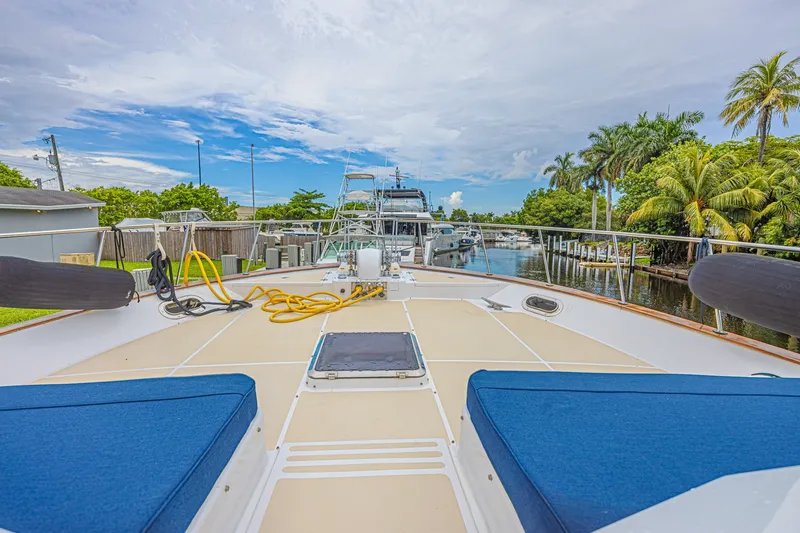 Slide: The Image of 2005 Grand Banks 72 Aleutian RP yacht docked, featuring spacious deck and blue cushions. - 16