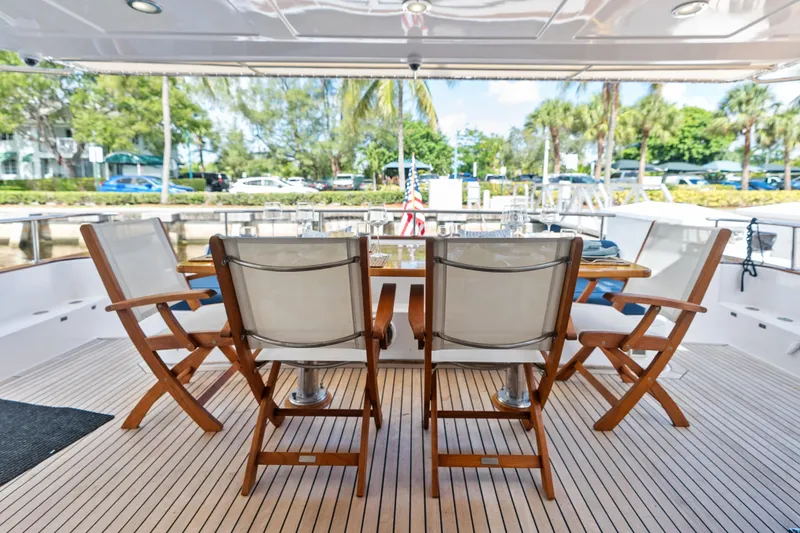 Slide: The Image of Outdoor dining area on 2005 Grand Banks 72 Aleutian RP yacht with wooden chairs and table. - 54
