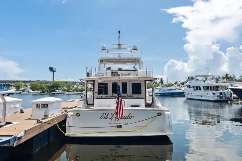 Slide: The Image of 2005 Grand Banks 72 Aleutian RP yacht docked at marina, rear view with American flag. - 187