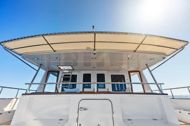 Slide: The Image of 2005 Grand Banks 72 Aleutian RP yacht, rear view with canopy and clear sky. - 177