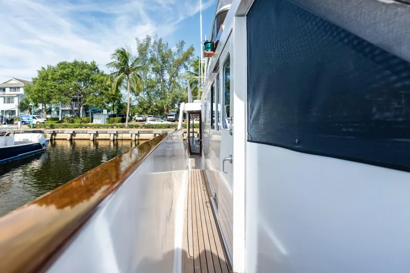 Slide: The Image of Side deck view of 2005 Grand Banks 72 Aleutian RP yacht docked by palm trees. - 124