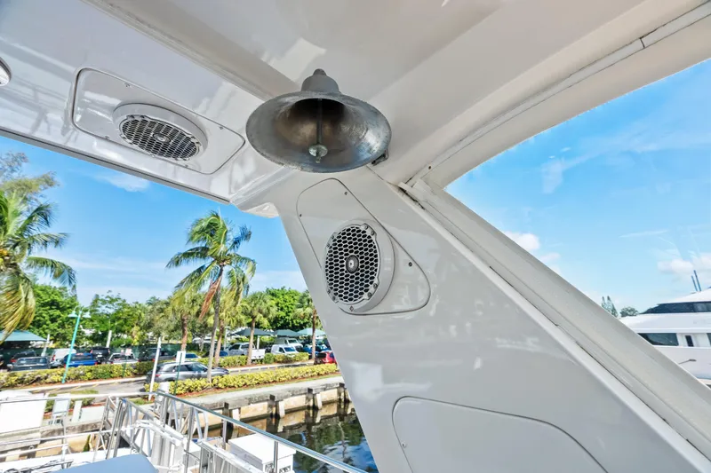 Slide: The Image of 2005 Grand Banks 72 Aleutian RP yacht detail with bell and speakers, docked near palm trees. - 132