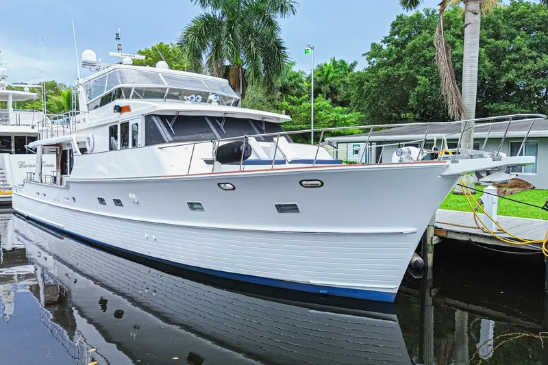 Slide: The Image of 2005 Grand Banks 72 Aleutian RP yacht docked near lush greenery. - 2