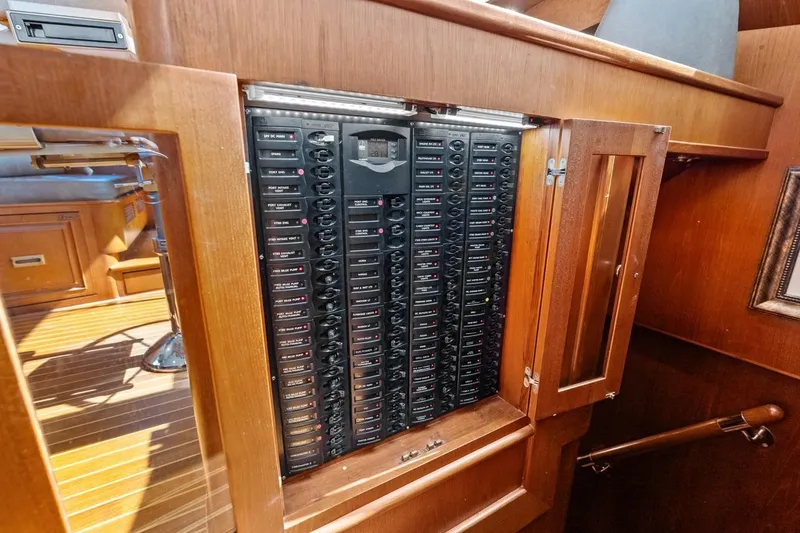 Slide: The Image of Electrical panel inside 2005 Grand Banks 72 Aleutian RP yacht, featuring wooden cabinetry. - 65