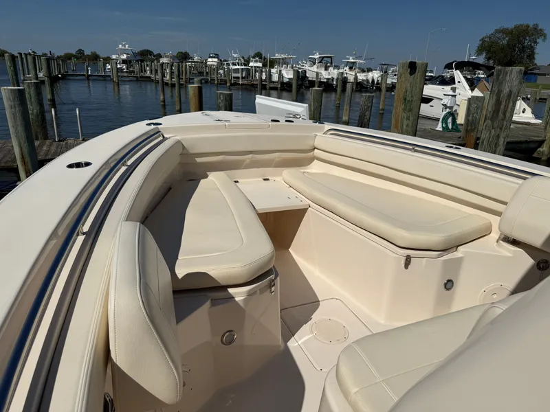 Slide: The Image of 2022 Grady-White Canyon 306 with beige upholstery and spacious seating area at the dock. - 23