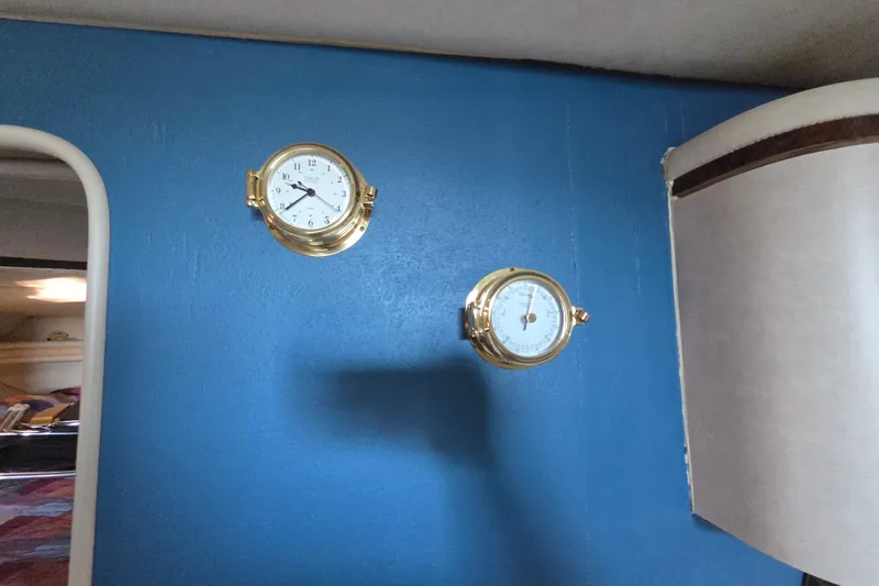 Slide: The Image of Gold nautical clock and barometer on blue wall inside 1997 Regal Commodore 402 boat. - 28