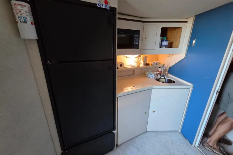 Slide: The Image of Compact kitchen area in a 1997 Regal Commodore 402 boat, featuring a sink and microwave. - 31