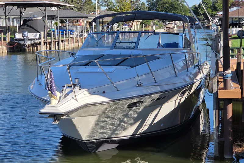 Slide: The Image of 1997 Regal Commodore 402 yacht docked in a serene marina setting. - 2