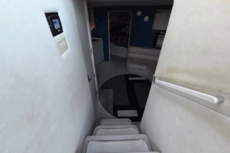 Slide: The Image of Interior view of 1997 Regal Commodore 402 yacht, featuring stairs and a cozy seating area. - 23