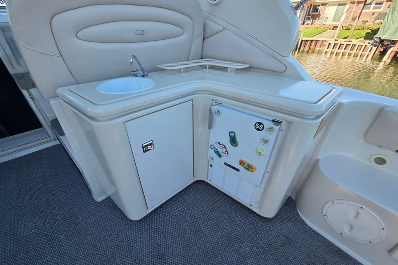 Slide: The Image of 1997 Regal Commodore 402 boat kitchenette with sink, mini fridge, and storage cabinet. - 16