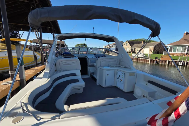 Slide: The Image of 1997 Regal Commodore 402 boat with spacious seating, docked in a scenic marina. - 14