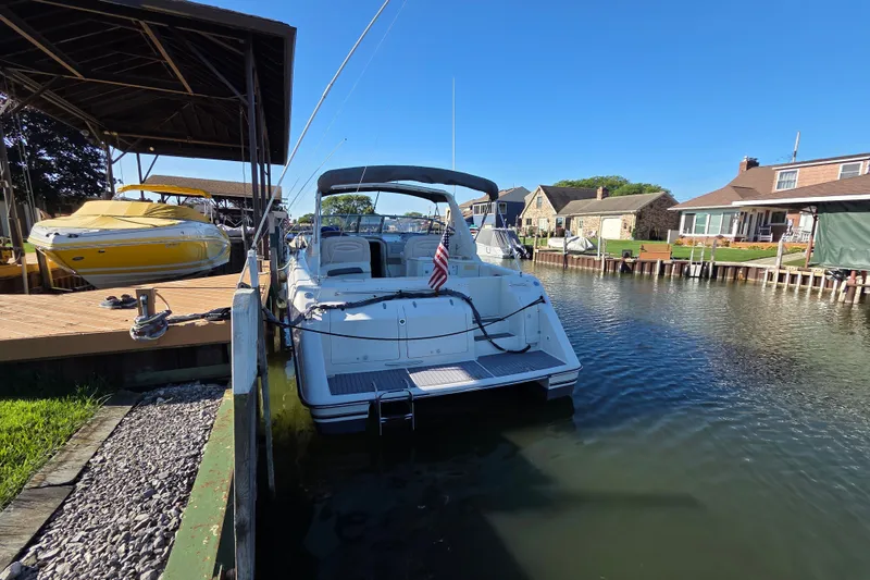 Slide: The Image of 1997 Regal Commodore 402 docked in a serene residential canal setting. - 5