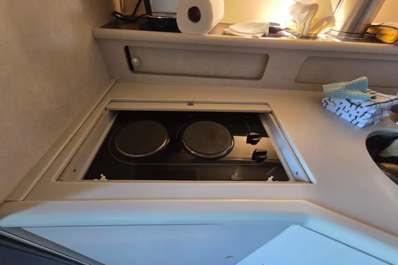 Slide: The Image of 1997 Regal Commodore 402 yacht kitchen with electric stove and countertop essentials. - 32