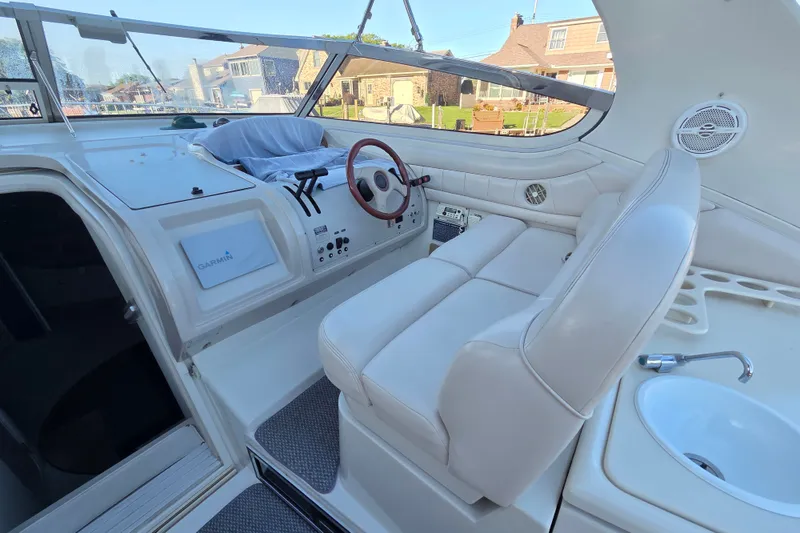 Slide: The Image of Interior of a 1997 Regal Commodore 402 yacht with white seating and steering wheel. - 18