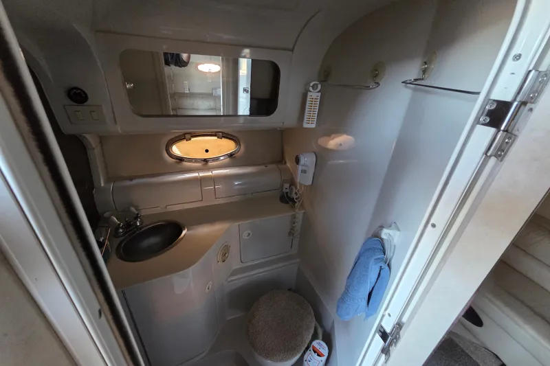 Slide: The Image of Compact bathroom in a 1997 Regal Commodore 402 boat, featuring sink and mirror. - 30