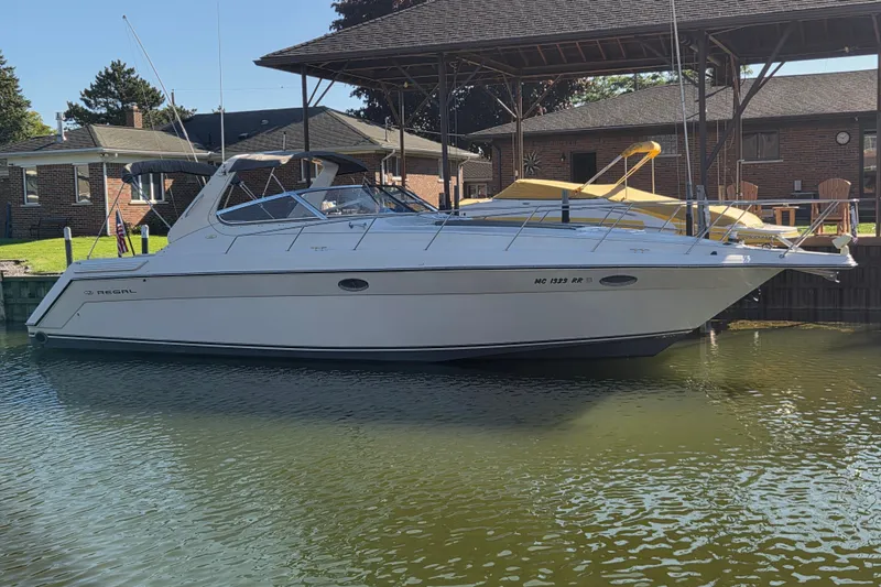 The Image of 1997 Regal Commodore 402 boat docked in a serene marina setting. - 1