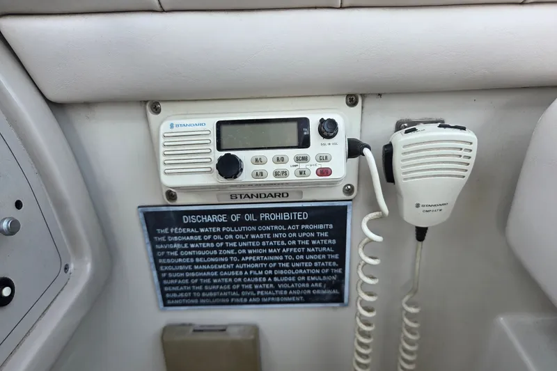 Slide: The Image of 1997 Regal Commodore 402 boat radio and microphone with oil discharge warning sign. - 43