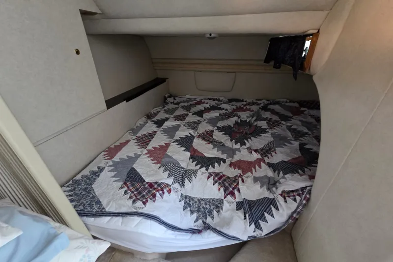 Slide: The Image of Cozy cabin interior of a 1997 Regal Commodore 402 with a patterned quilted bedspread. - 25
