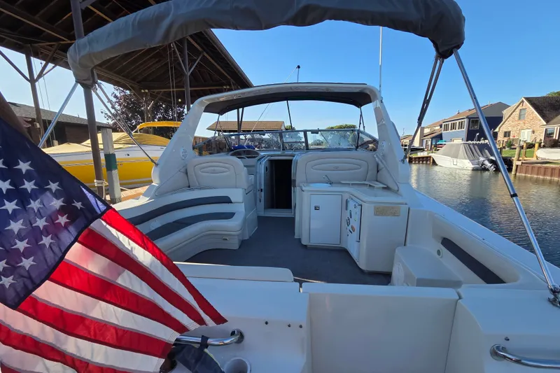 Slide: The Image of 1997 Regal Commodore 402 boat interior with American flag, docked in a marina. - 13