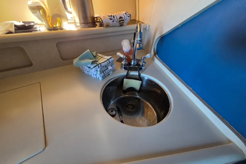 Slide: The Image of Compact kitchen sink area in a 1997 Regal Commodore 402 boat. - 33