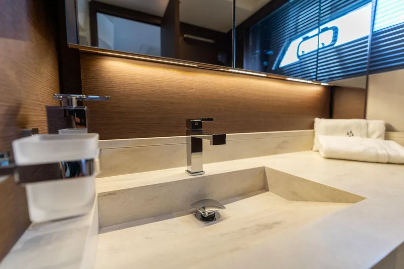 Slide: The Image of Modern bathroom sink in 2022 Prestige 520 yacht, featuring sleek design and ambient lighting. - 15