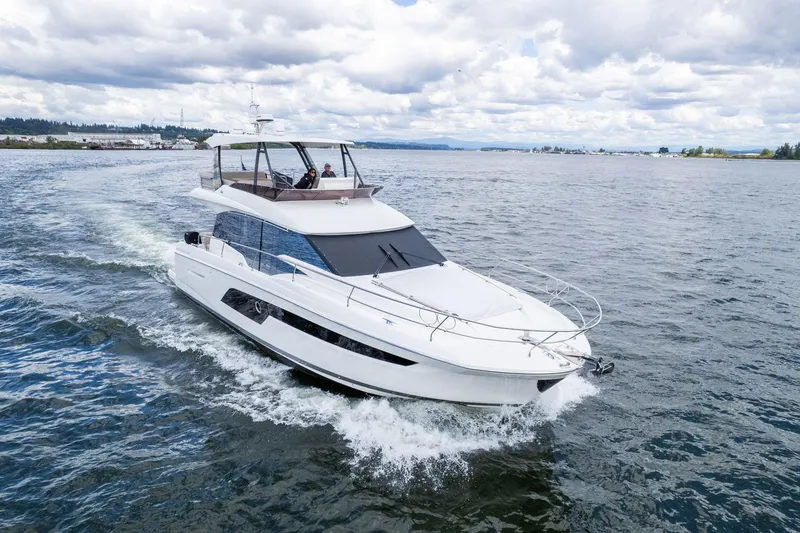 Slide: The Image of 2022 Prestige 520 yacht cruising on open water under cloudy skies. - 1