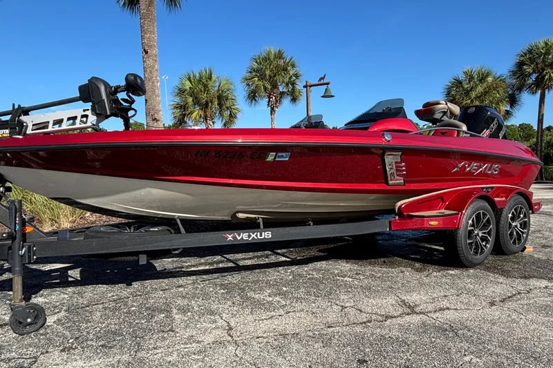 The Image of 2020 Vexus VX20 boat on trailer, vibrant red, parked under palm trees. - 1