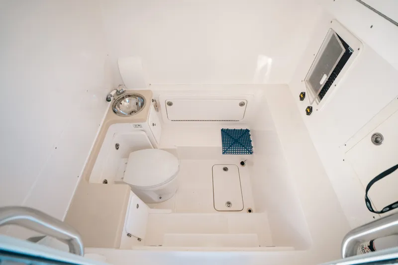 Slide: The Image of Interior of 2013 Invincible 42 Open Fisherman boat, featuring a compact bathroom setup. - 57