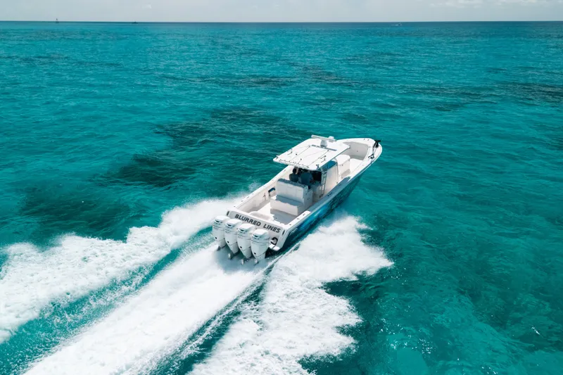 Slide: The Image of 2013 Invincible 42 Open Fisherman speeding on turquoise ocean waters. - 14