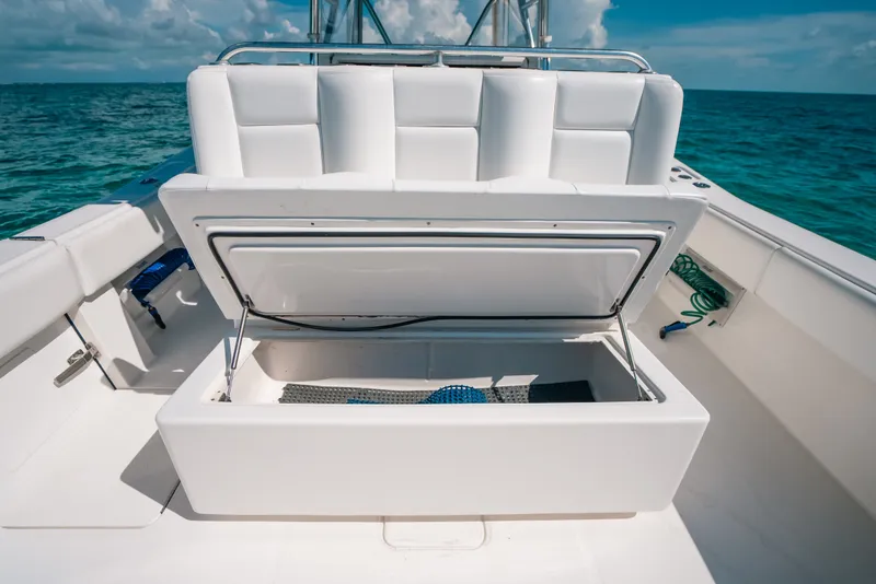 Slide: The Image of 2013 Invincible 42 Open Fisherman boat with open storage compartment, ocean backdrop. - 49