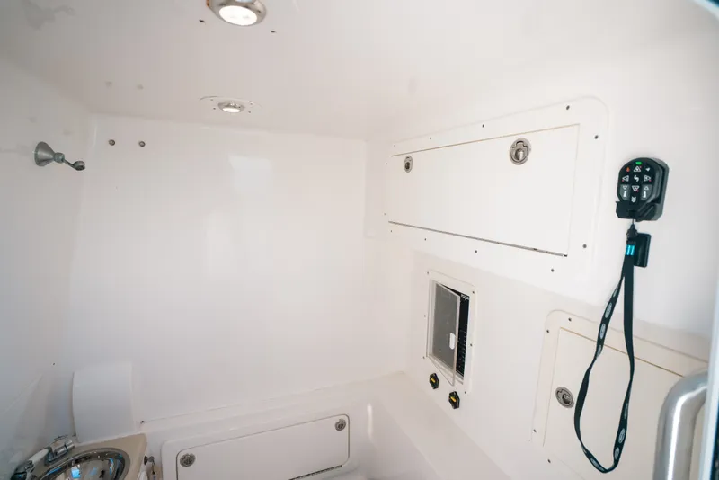 Slide: The Image of Interior of 2013 Invincible 42 Open Fisherman boat, featuring storage compartments and control panel. - 56