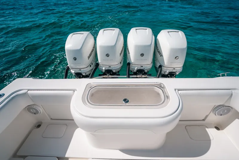Slide: The Image of 2013 Invincible 42 Open Fisherman boat with four powerful outboard engines on blue ocean water. - 44