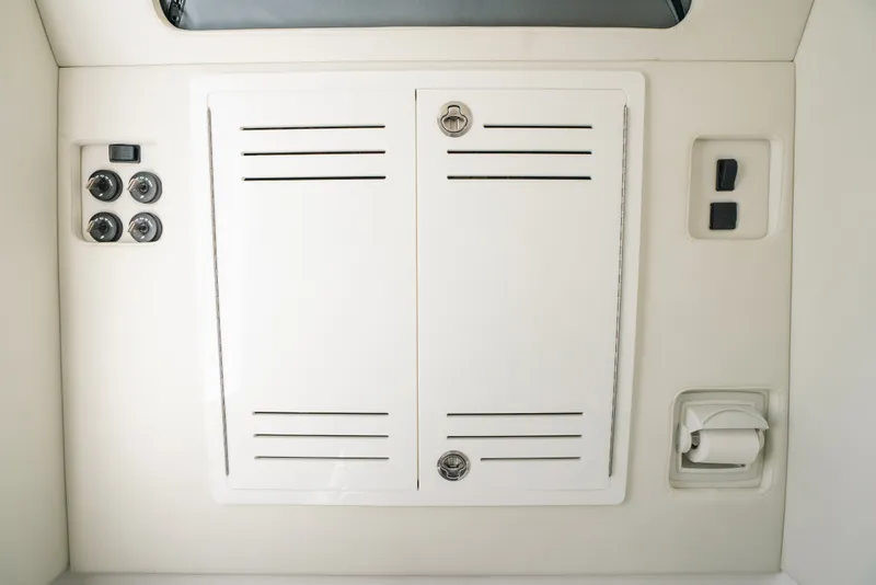 Slide: The Image of Control panel on a 2013 Invincible 42 Open Fisherman boat, featuring switches and storage. - 55