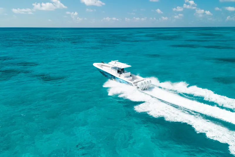Slide: The Image of 2013 Invincible 42 Open Fisherman cruising on clear turquoise ocean waters. - 15