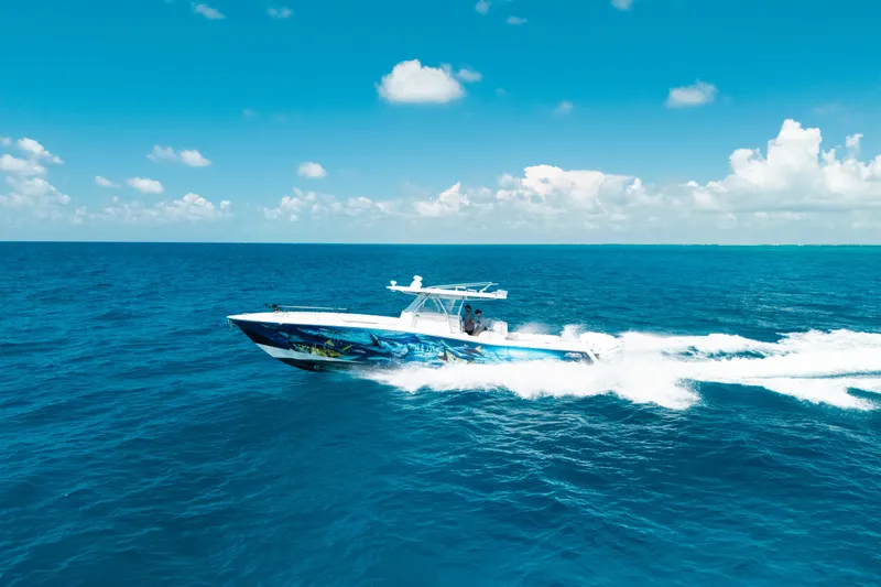 Slide: The Image of 2013 Invincible 42 Open Fisherman cruising on clear blue ocean under sunny skies. - 16