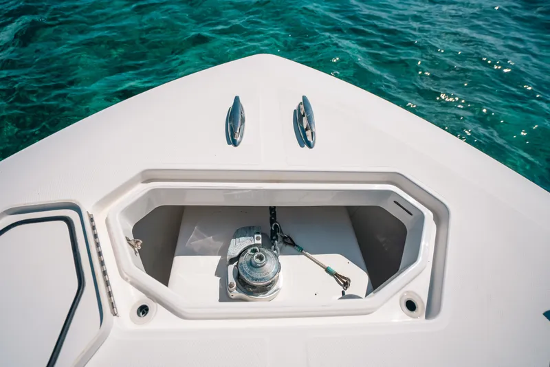 Slide: The Image of Bow of 2013 Invincible 42 Open Fisherman with anchor locker, on clear blue water. - 23
