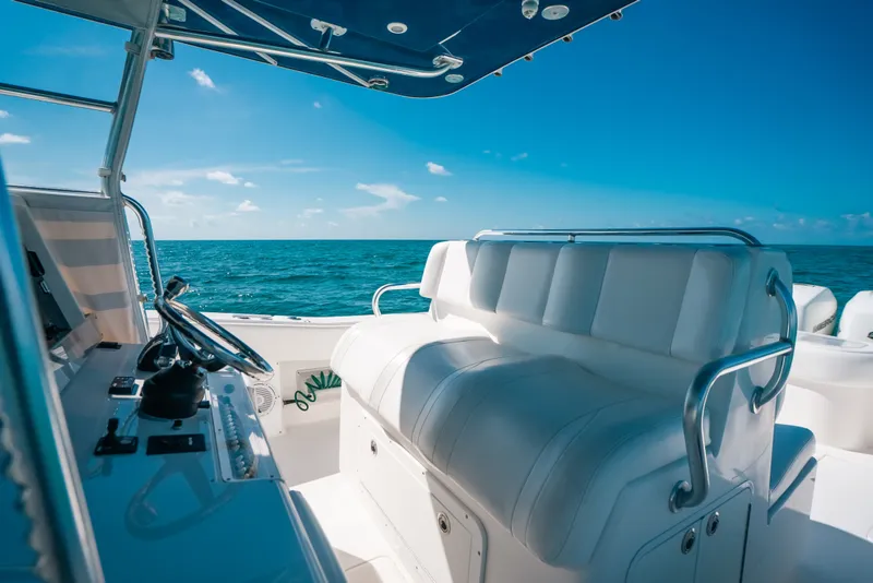 Slide: The Image of Invincible 42 Open Fisherman 2013 boat interior with ocean view, featuring white seating and steering console. - 28