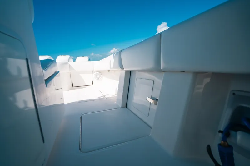 Slide: The Image of 2013 Invincible 42 Open Fisherman boat interior with sleek white design under clear blue sky. - 40