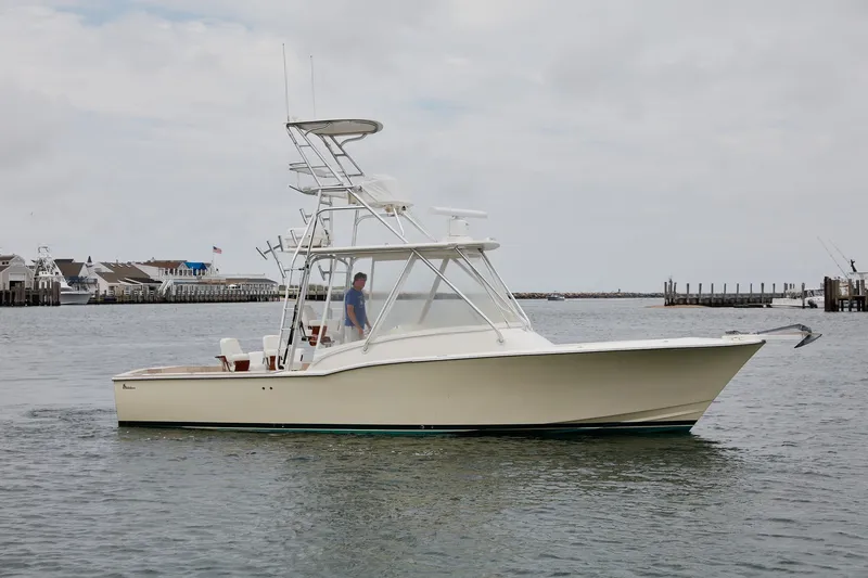 The Image of 2009 L&H 33 Walkaround boat cruising in a harbor with docks in the background. - 0