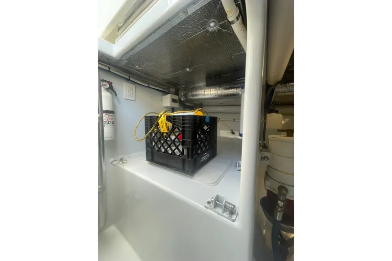 Slide: The Image of Engine compartment of 2009 L&H 33 Walkaround boat with storage crate and fire extinguisher. - 23